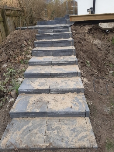 Udendørs trappe i betonfliser anlagt i have ved hus