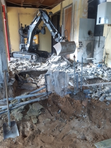 Indvendig nedrivning ved tømning af hus udført med minigraver som forberedelse til renovering.